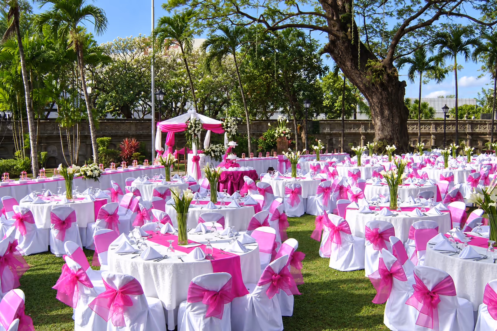 Jojie’s outdoor catered event with white-dressed tables and magenta accents