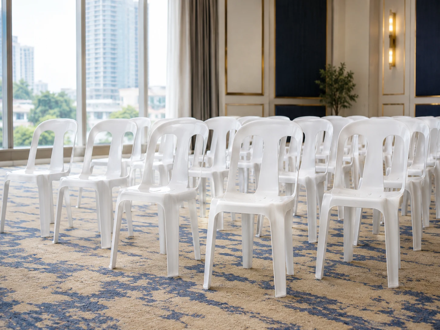 Rows of plain white monobloc chairs arranged for an indoor event in Manila